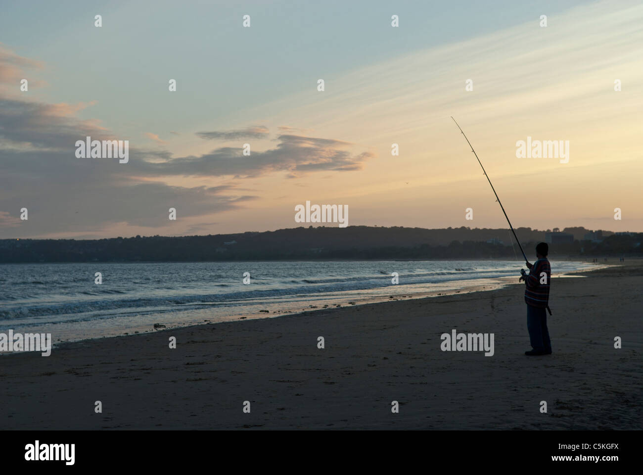 Pescatore solitario sulla spiaggia Foto Stock