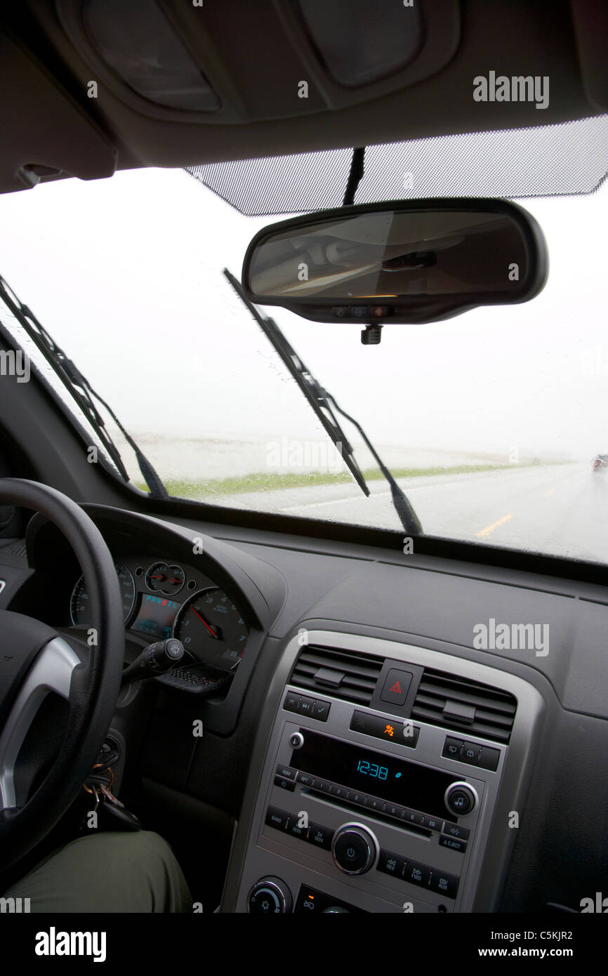 Guida auto sulla sola autostrada attraverso la pioggia torrenziale e campi di allagamento nel sud del Saskatchewan canada Foto Stock