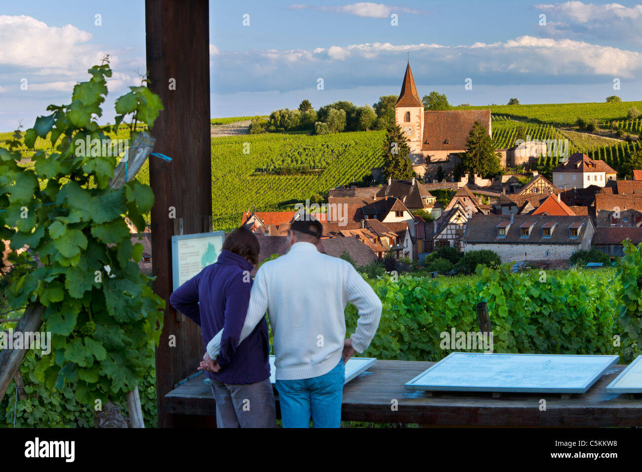 Giovane godendo della vista sul borgo medioevale di Hunawihr lungo la strada del vino Alsaziano Haut-Rhin Francia Foto Stock