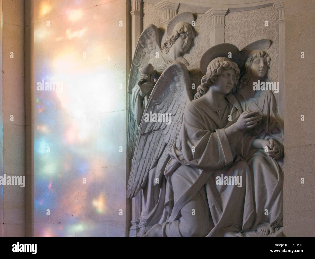Bassorilievo scultura di 3 angeli nella navata nord ambulatorio con pezzata luce colorata, Cattedrale del Santissimo Sacramento, Foto Stock