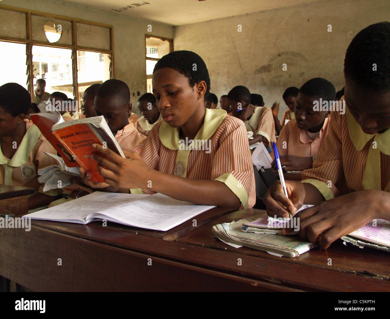 Lagos, Nigeria: Teenage studentessa seduti ad una scrivania in una classe di una scuola pubblica. Gli studenti di indossare un uniforme. Foto Stock