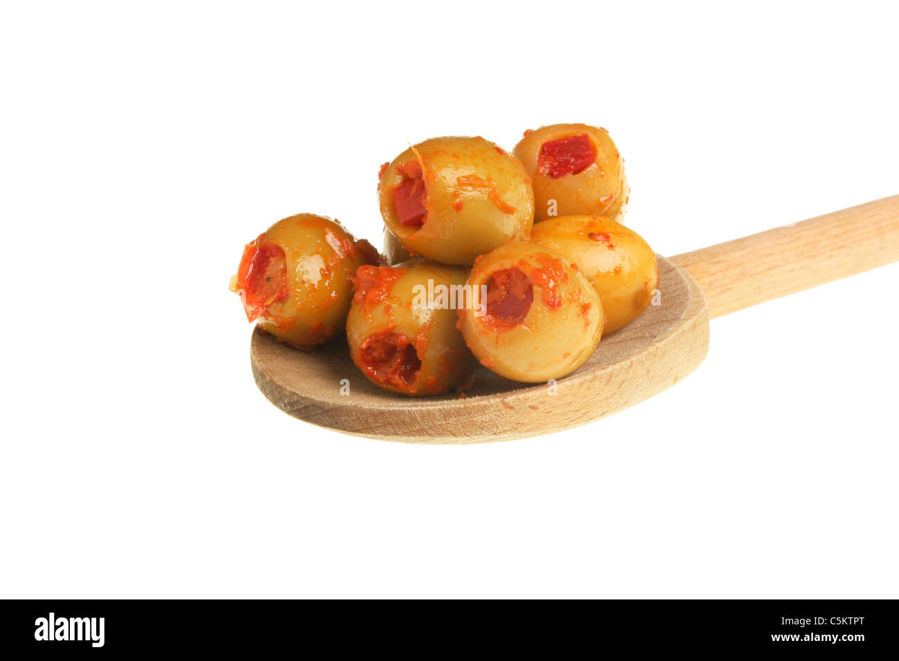 Olive farcite su un cucchiaio di legno isolata contro bianco Foto Stock