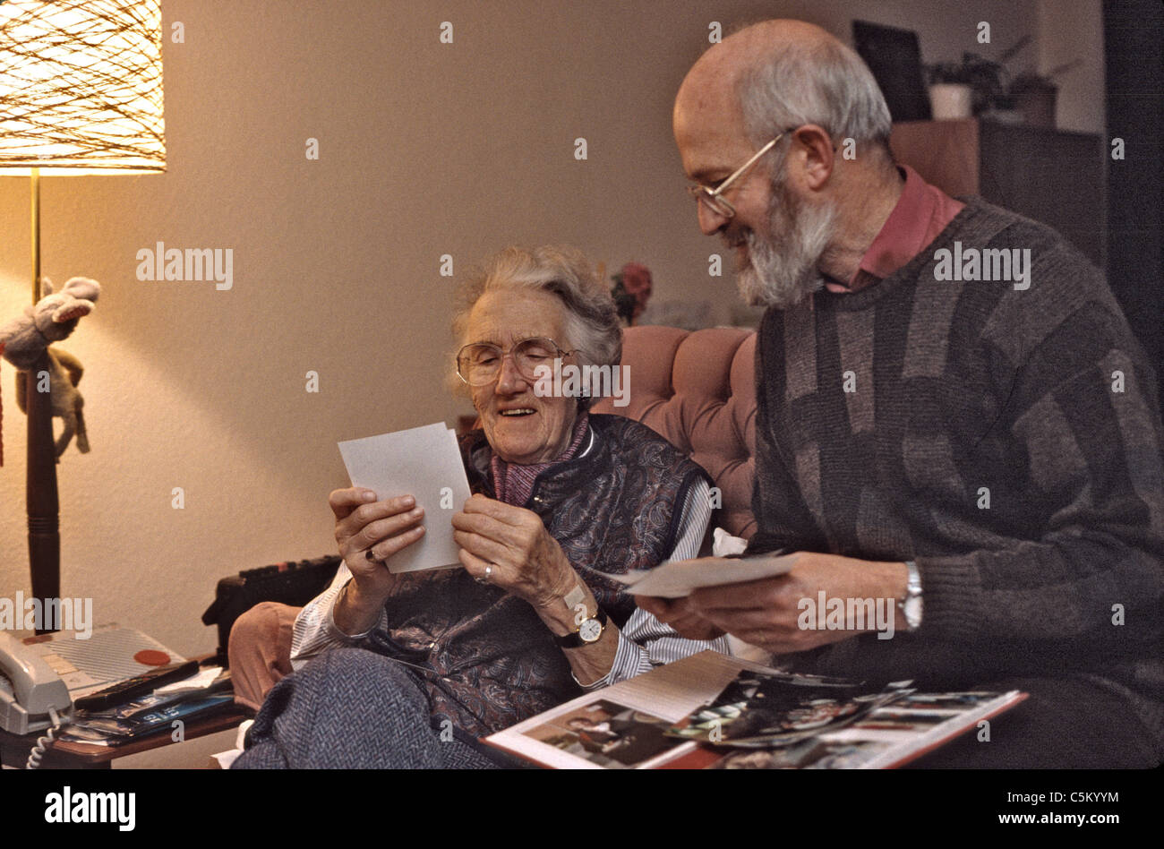 Due anziani guardando le foto ricordando Foto Stock