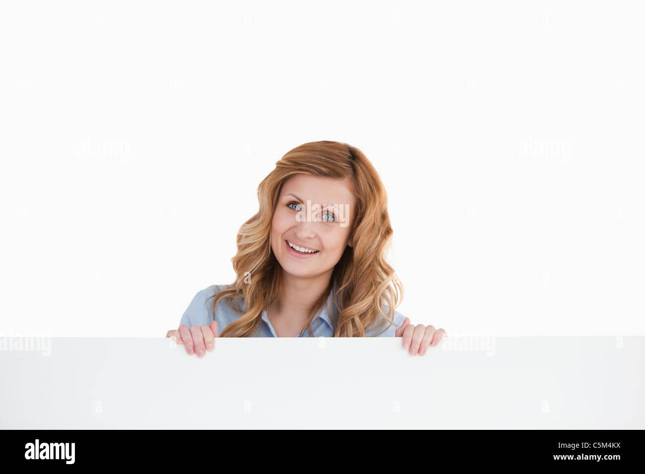 Donna bionda sorridente dietro una lavagna vuota Foto Stock