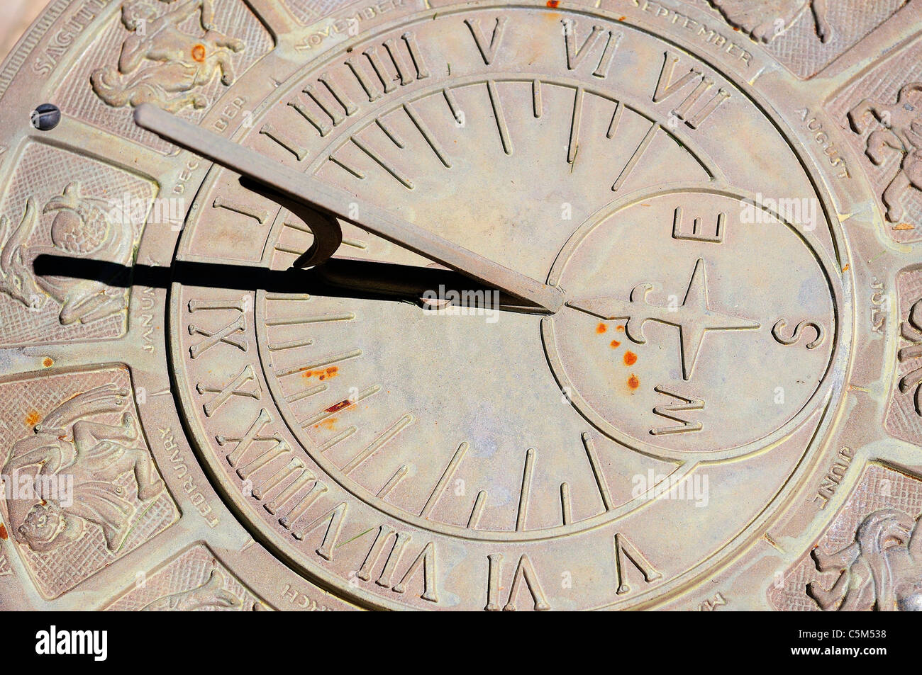 Orologio solare con segni zodiacali e figure che circonda il numero romano volte. Foto Stock