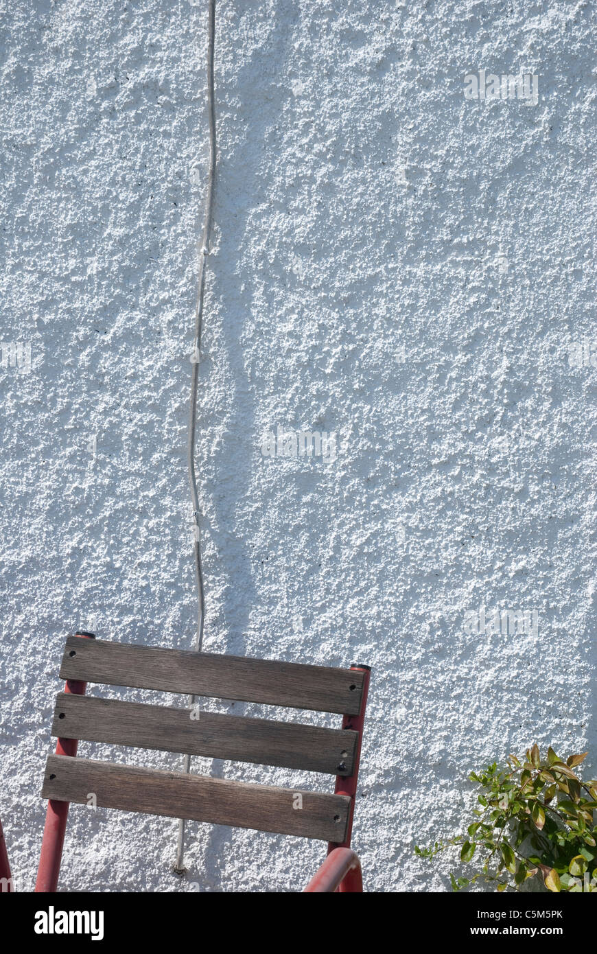 Schienale contro un bianco di ghiaia parete discontinua Foto Stock