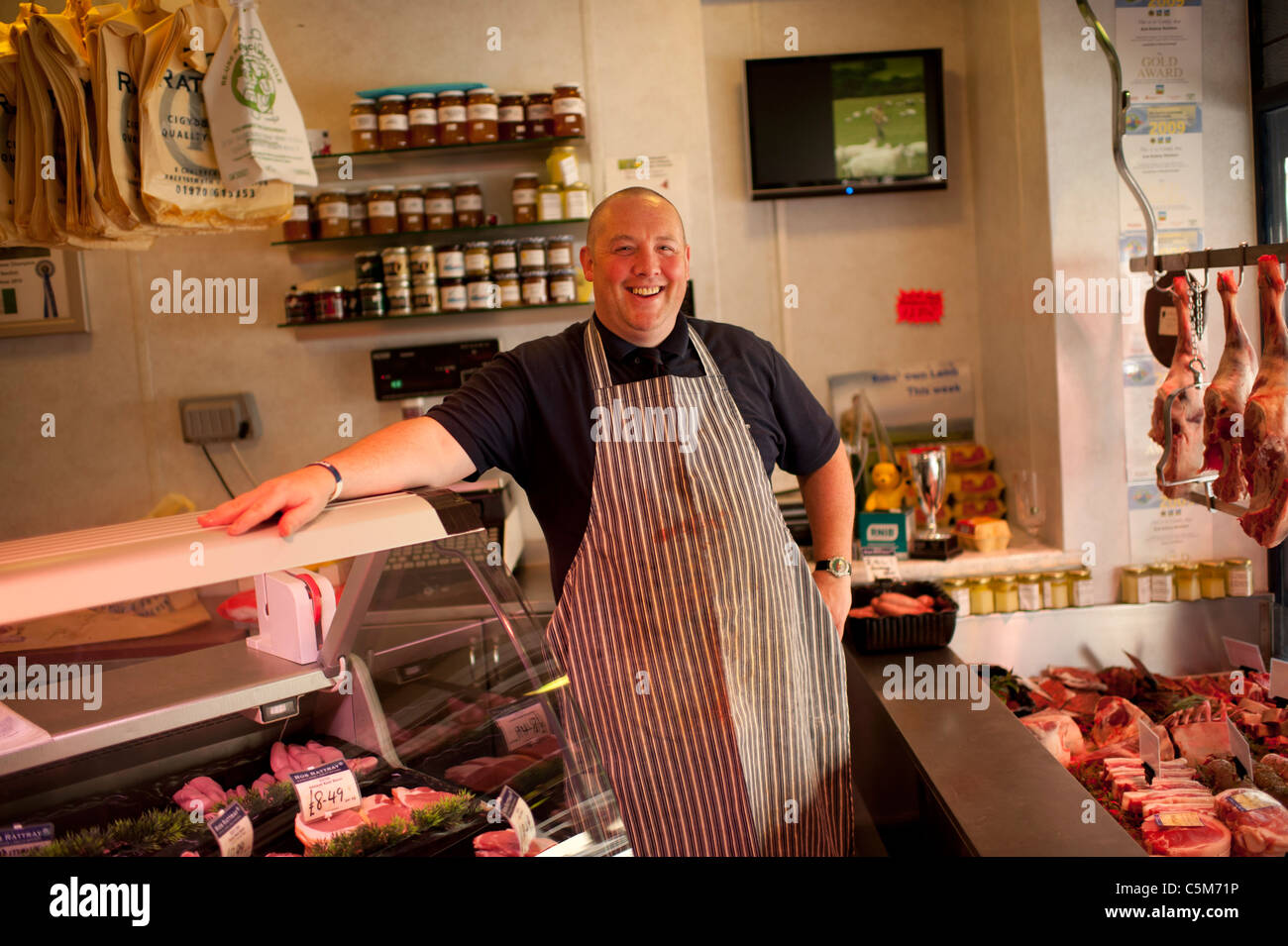 Un sorridenti jolly fat Butcher nel suo negozio, Aberystwyth Wales UK Foto Stock
