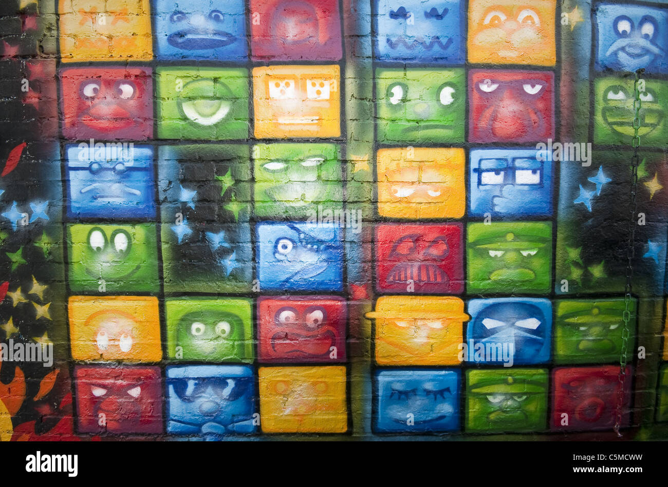Graffiti del quadrato delle espressioni facciali a Friedrichshain dietro la East Side Gallery di Berlino, Germania Foto Stock