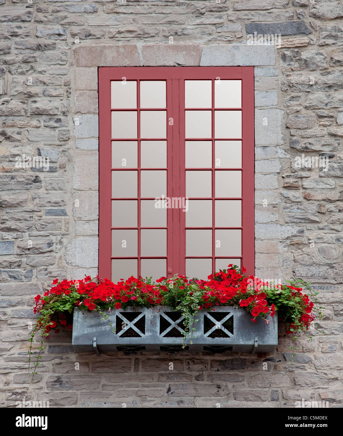 Vista frontale di una vecchia finestra e una fioriera su un vecchio edificio in pietra. Foto Stock
