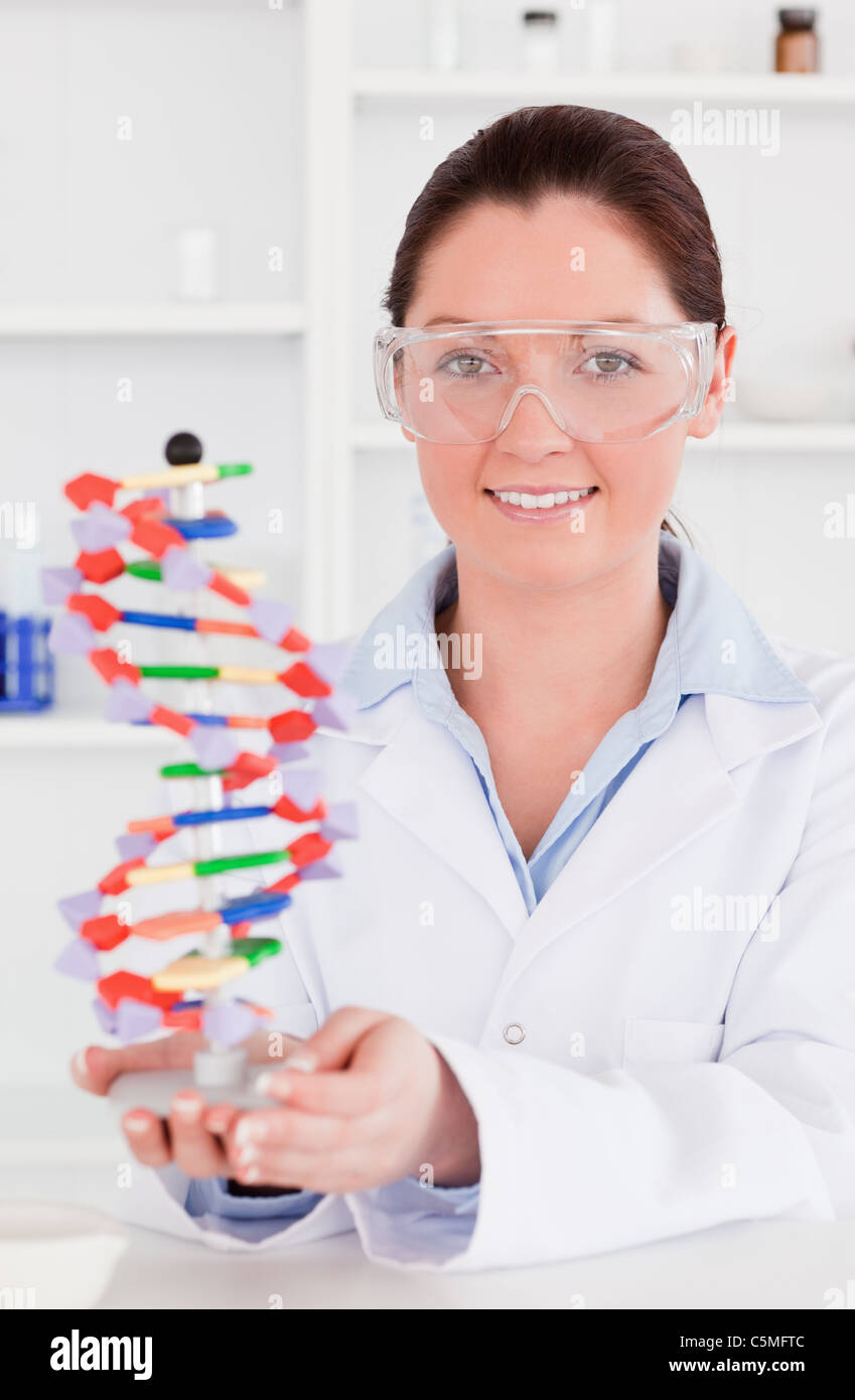 Ritratto di un simpatico scienziato che mostra la doppia elica del DNA modello Foto Stock