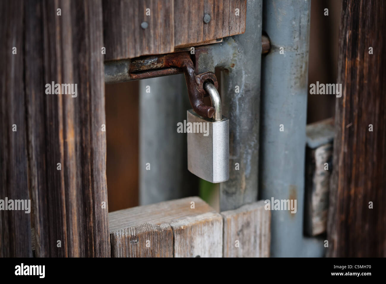 Rusty cancello in legno con lucchetto Foto Stock