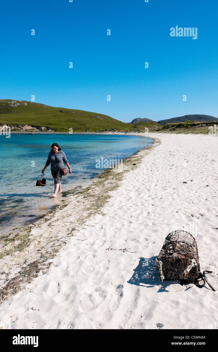 Un viandante paddling in Vatersay Bay nelle Ebridi Esterne Foto Stock