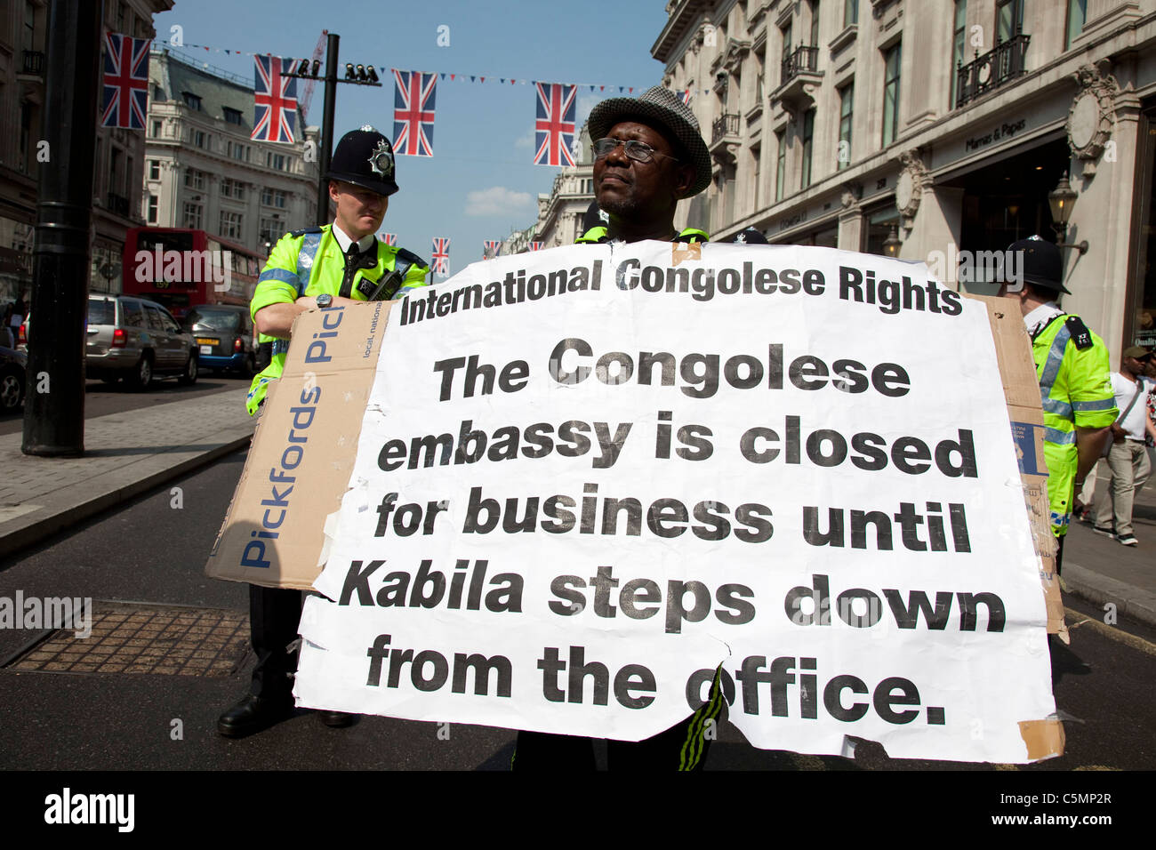 Dimostrazione su Regents Street nel centro di Londra dal popolo congolese che protestavano per i loro diritti. Pposters si lamentano del fatto che David Cameron è troppo tranquilla sul soggetto e che l'ambasciata rimarrà chiusa fino a quando il presidente della Repubblica Democratica del Congo, Joseph Kabila passi verso il basso. Questa demo è stata ufficiale, e pesantemente presidiate. Foto Stock