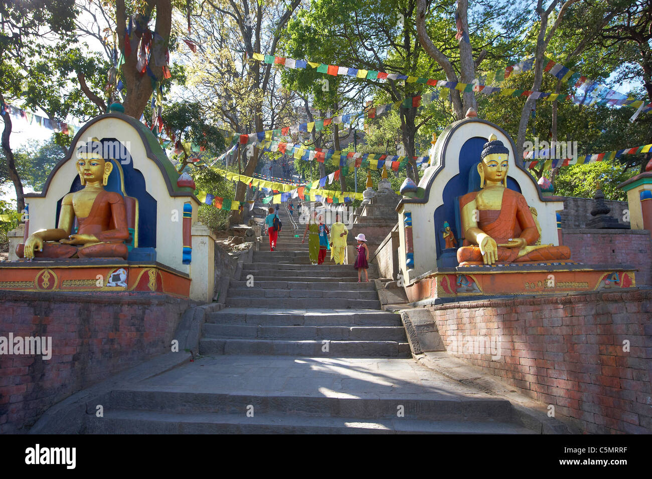 Statue di Buddha a guardia della scale e bandiere di preghiera che conduce fino a Swayambhunath tempio buddista, Kathmandu, Nepal, Asia Foto Stock