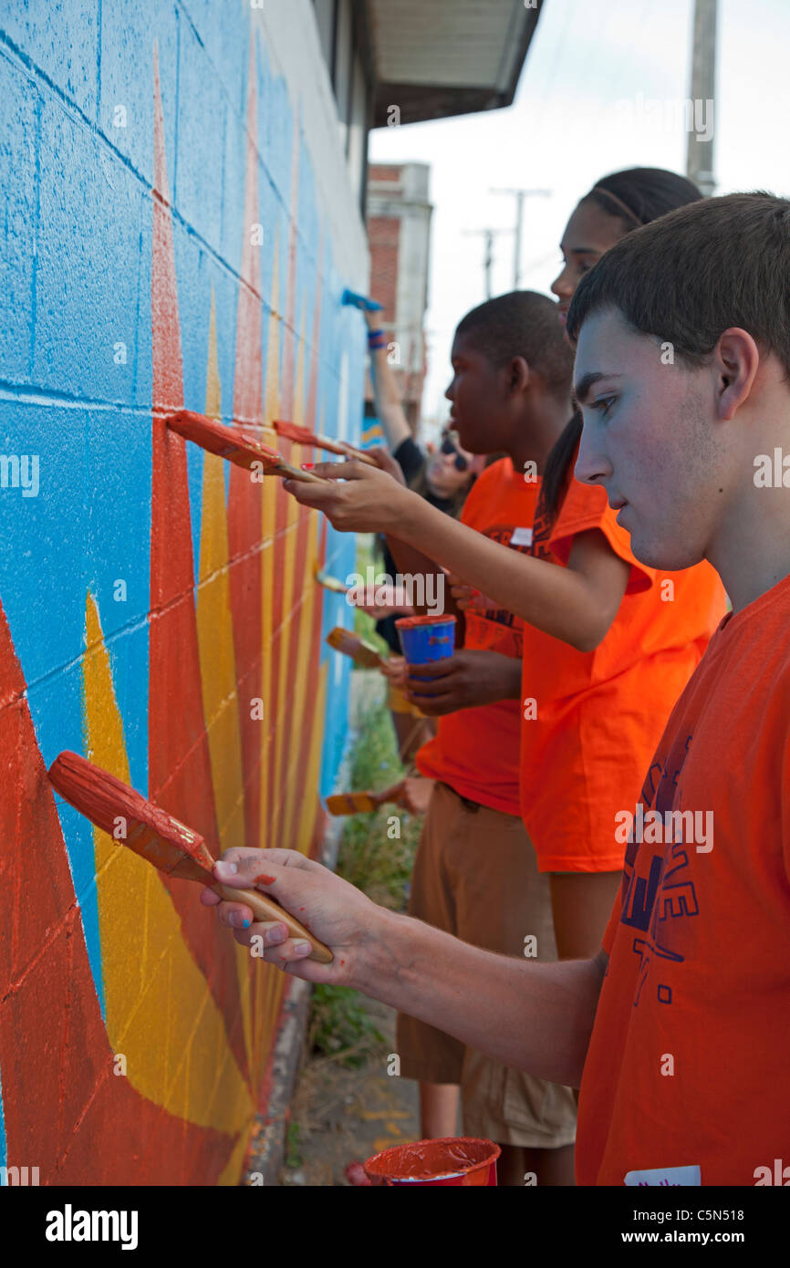Detroit, Michigan - Alta scuola volontari vernice su un edificio vuoto. Essi stanno lavorando per tutta l'estate in città programma. Foto Stock
