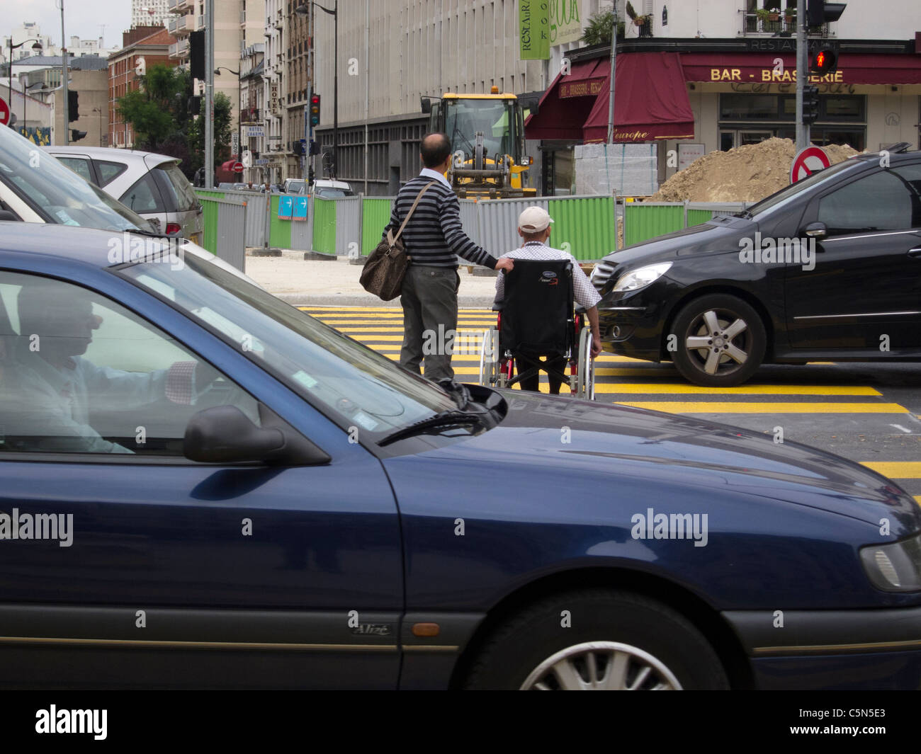 Parigi, Francia, uomo con handicap in sedia a rotelle, Crossing Street in Busy Traffic, Tramway Construction Site, Cars Street Scene Foto Stock