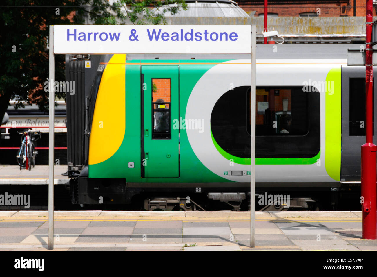 London Midland moderno treno & drivers cabina incorniciata da Harrow & Wealdstone stazione ferroviaria sign in attesa di partono i mezzi di trasporto pubblici Stazione REGNO UNITO Inghilterra Foto Stock