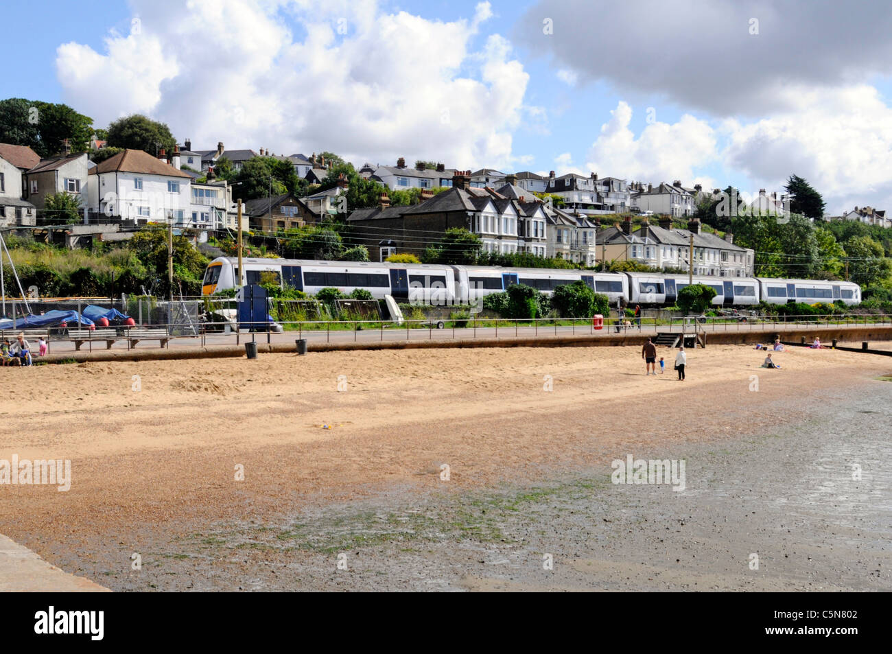 Spiaggia sabbiosa C2C di treno che viaggia tra Southend e stazioni di Londra si vede a Leigh on Sea estuario del Tamigi Essex Coast Inghilterra REGNO UNITO Foto Stock