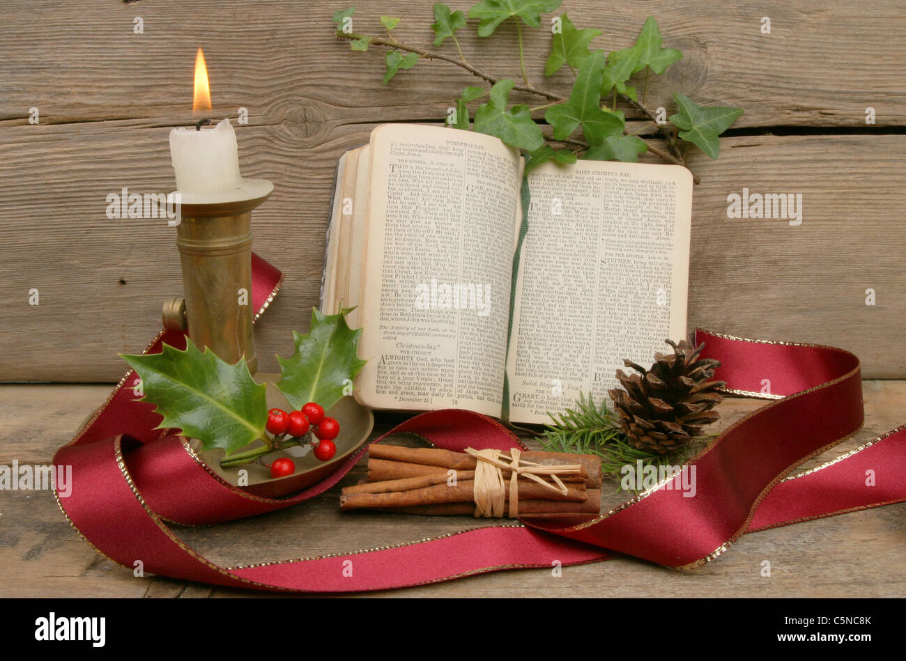 Tema Natale ancora in vita con una candela e libro di preghiera Foto Stock