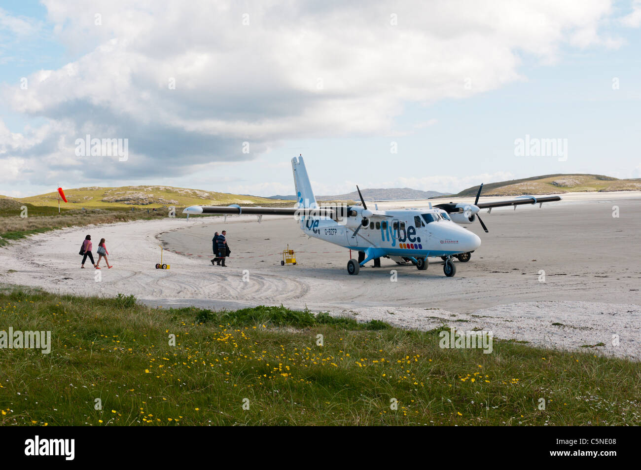 I passeggeri di salire a bordo di un aereo di Flybe - Loganair sulla spiaggia pista di atterraggio per aerei sull'isola di Barra nelle Ebridi Esterne Foto Stock