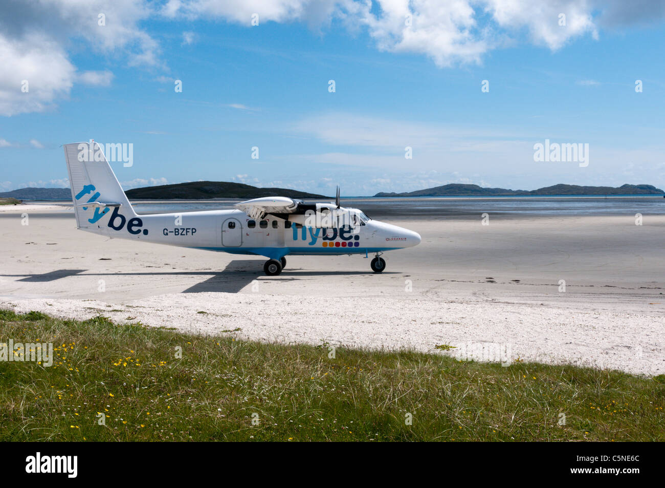 Un de Havilland DHC-6 Twin Otter piano di Flybe - Loganair sulla spiaggia pista di atterraggio per aerei sull'isola di Barra nelle Ebridi Esterne Foto Stock