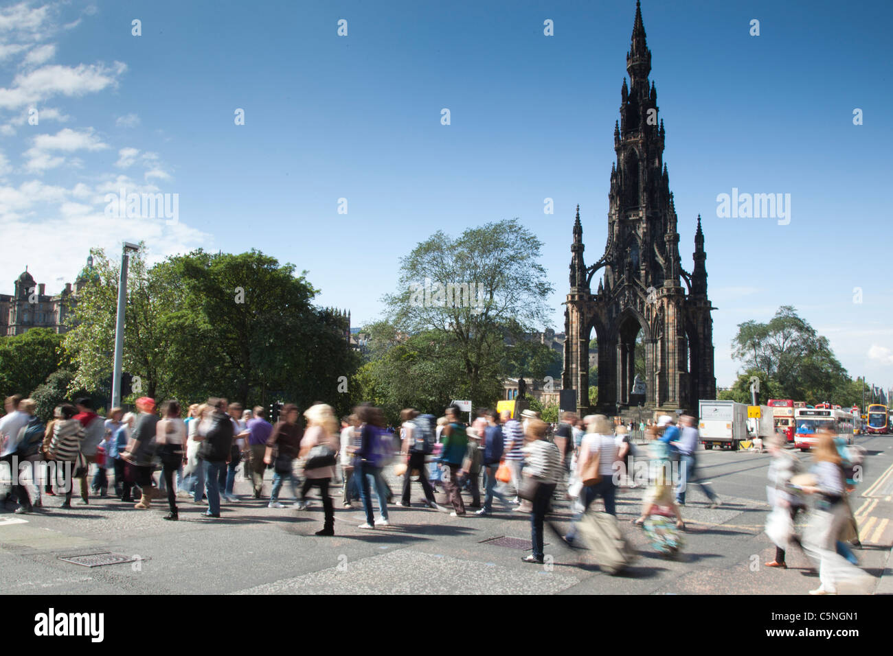 Pedoni che attraversano Princes street vicino al monumento di Scott, Edimburgo Foto Stock