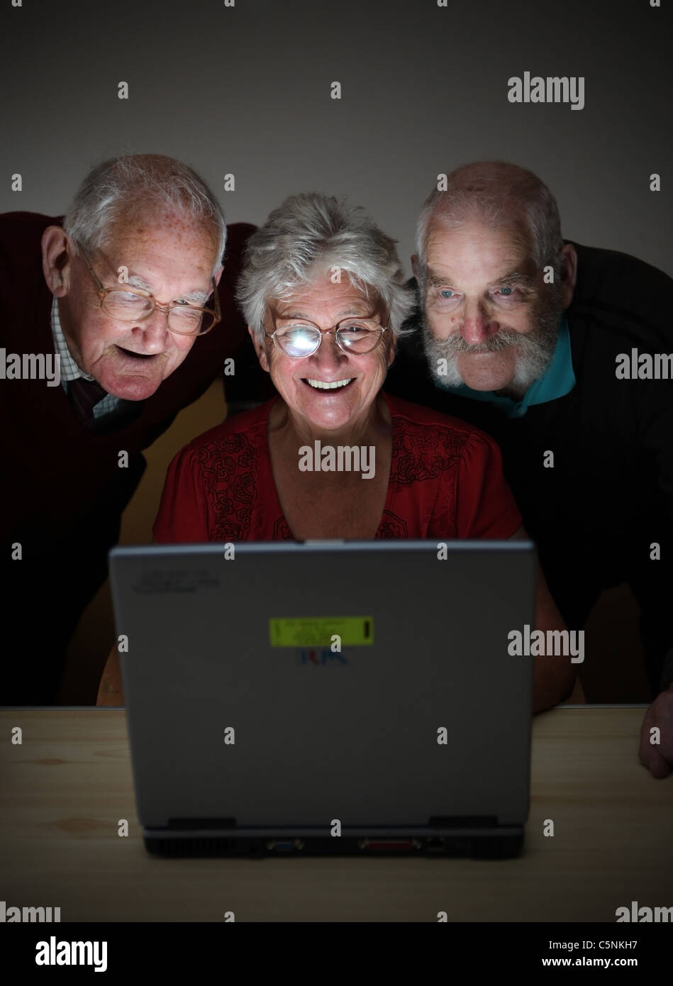 Le persone anziane guardando lo schermo e godendo utilizzando un moderno computer portatile Foto Stock
