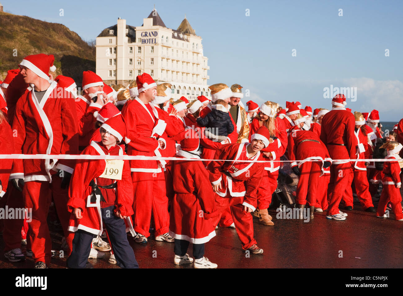 Llandudno, Conwy, il Galles del Nord, Regno Unito, Europa. Inizio di Babbi Natale Natale carità fundraising fun run sul lungomare Foto Stock