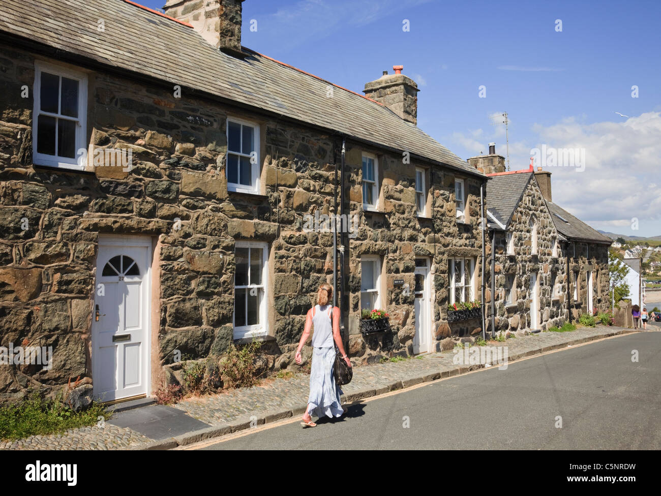 Fila di tradizionale antica pietra gallese casette a schiera. Ffordd Castell, a Criccieth, Lleyn Peninsula, Gwynedd, il Galles del Nord, Regno Unito, Gran Bretagna Foto Stock