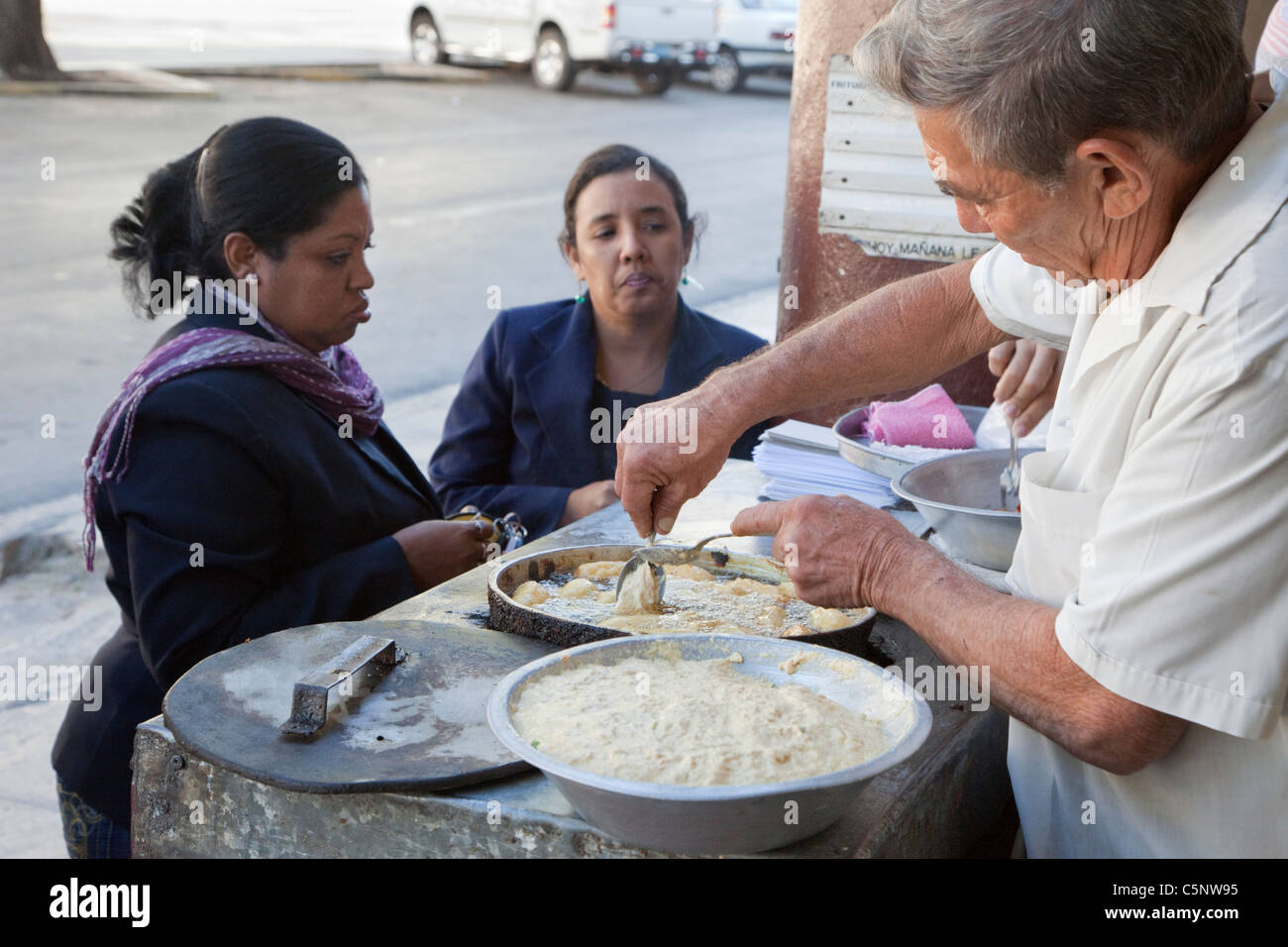 Cuba, La Habana. Cibo di strada frittura Vendor pasticceria mentre i clienti attendono. Foto Stock