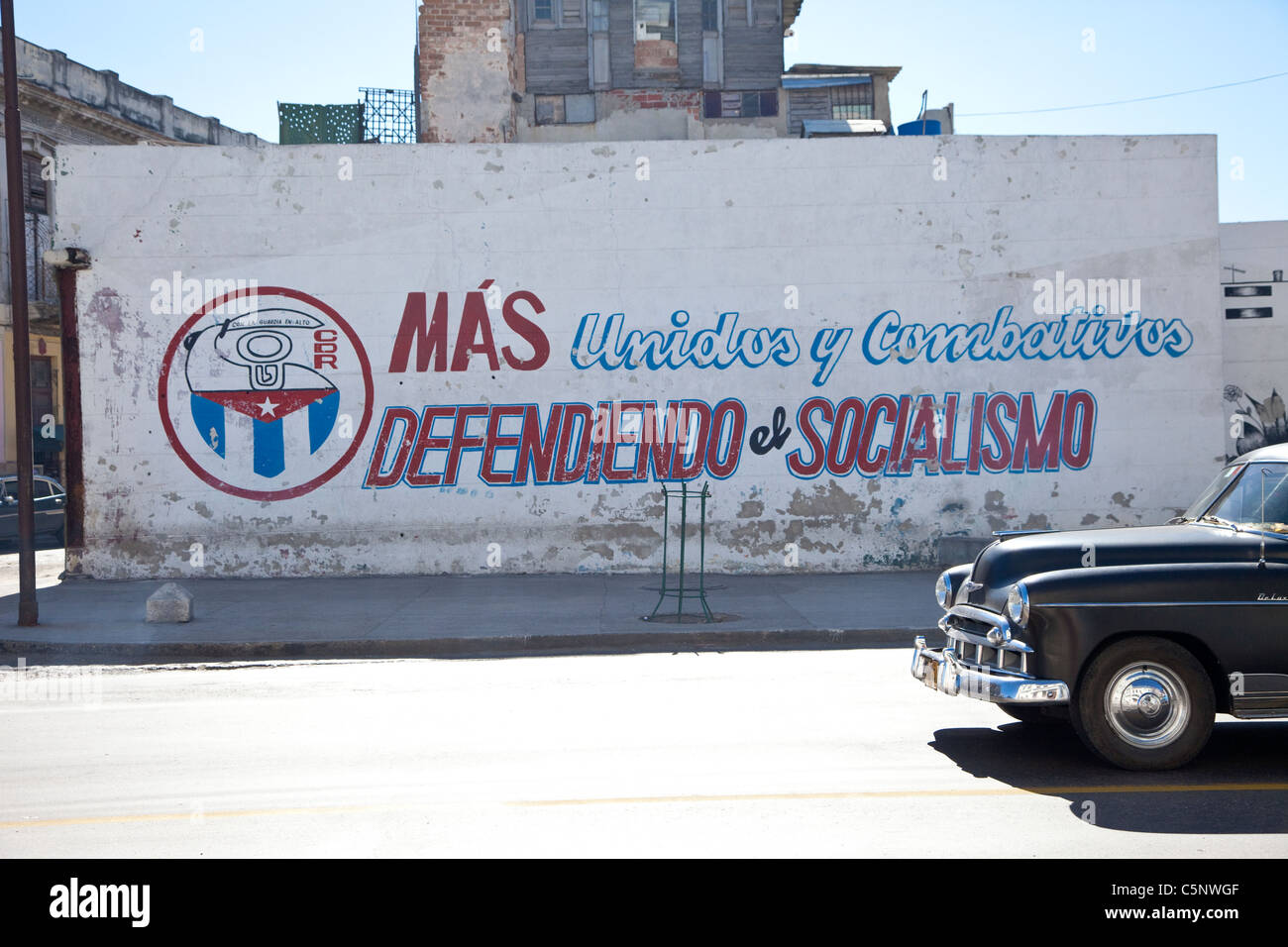 Cuba, La Habana. Slogan politici: più uniti e più combattivo, difendendo il socialismo." 1949 Chevrolet. Foto Stock