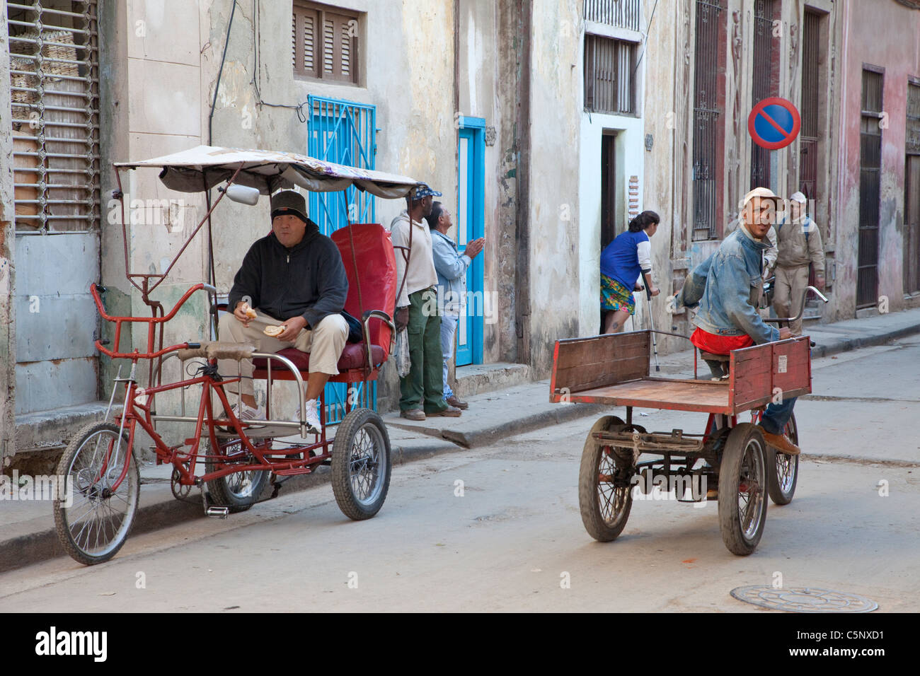Cuba, La Habana. Tre ruote di trasporto. Bicitaxi conducente attende per un cliente. Foto Stock