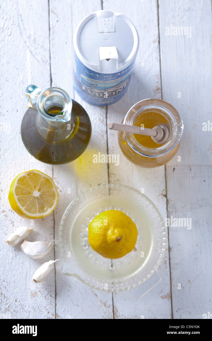 Ingredienti: un mezzo limone sul spremitore di limone, aglio, limone, olio  di oliva, il miele e il sale dietro Foto stock - Alamy