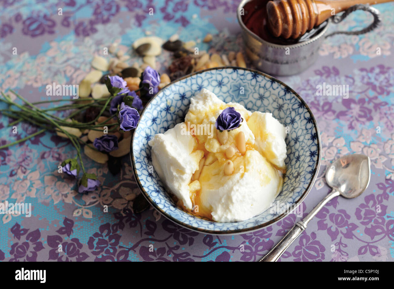 Yogurt greco con miele e pinoli Foto Stock