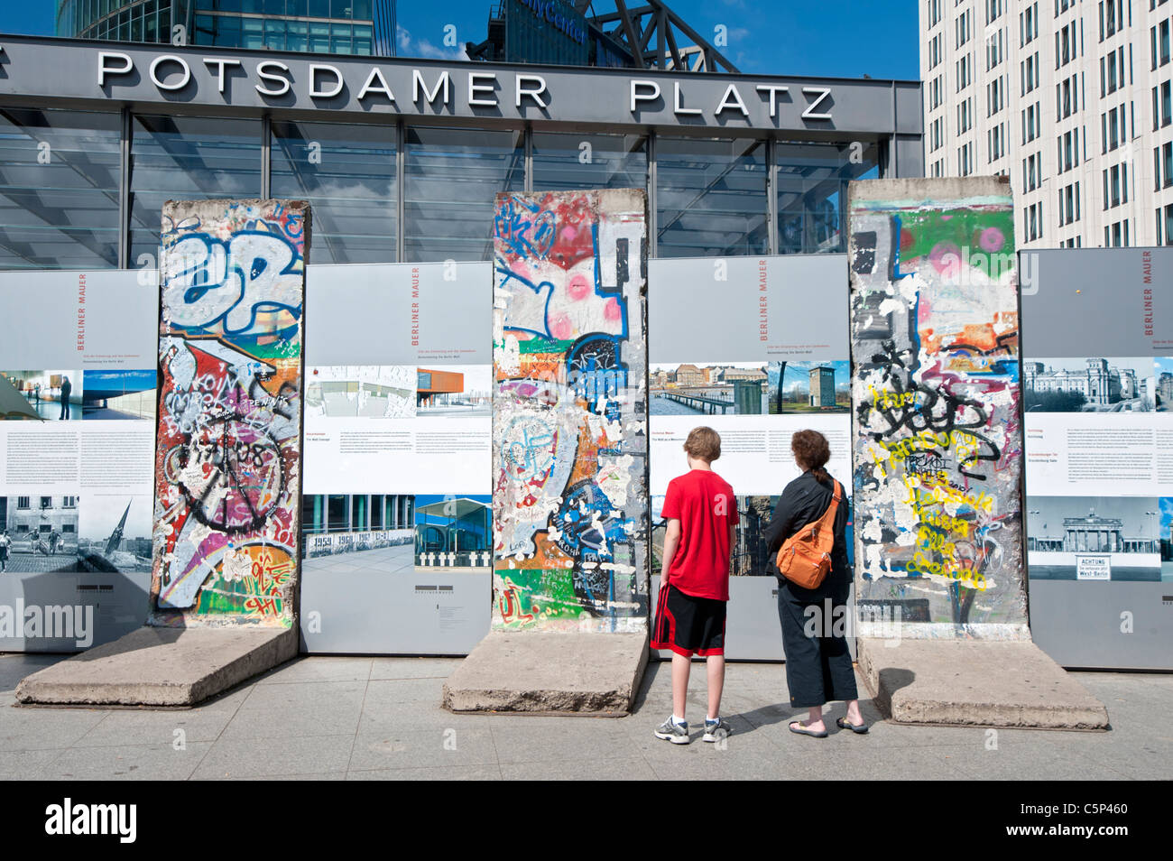 I turisti alla ricerca di sezioni originali del muro di Berlino a Potsdamer Platz a Berlino Germania Foto Stock