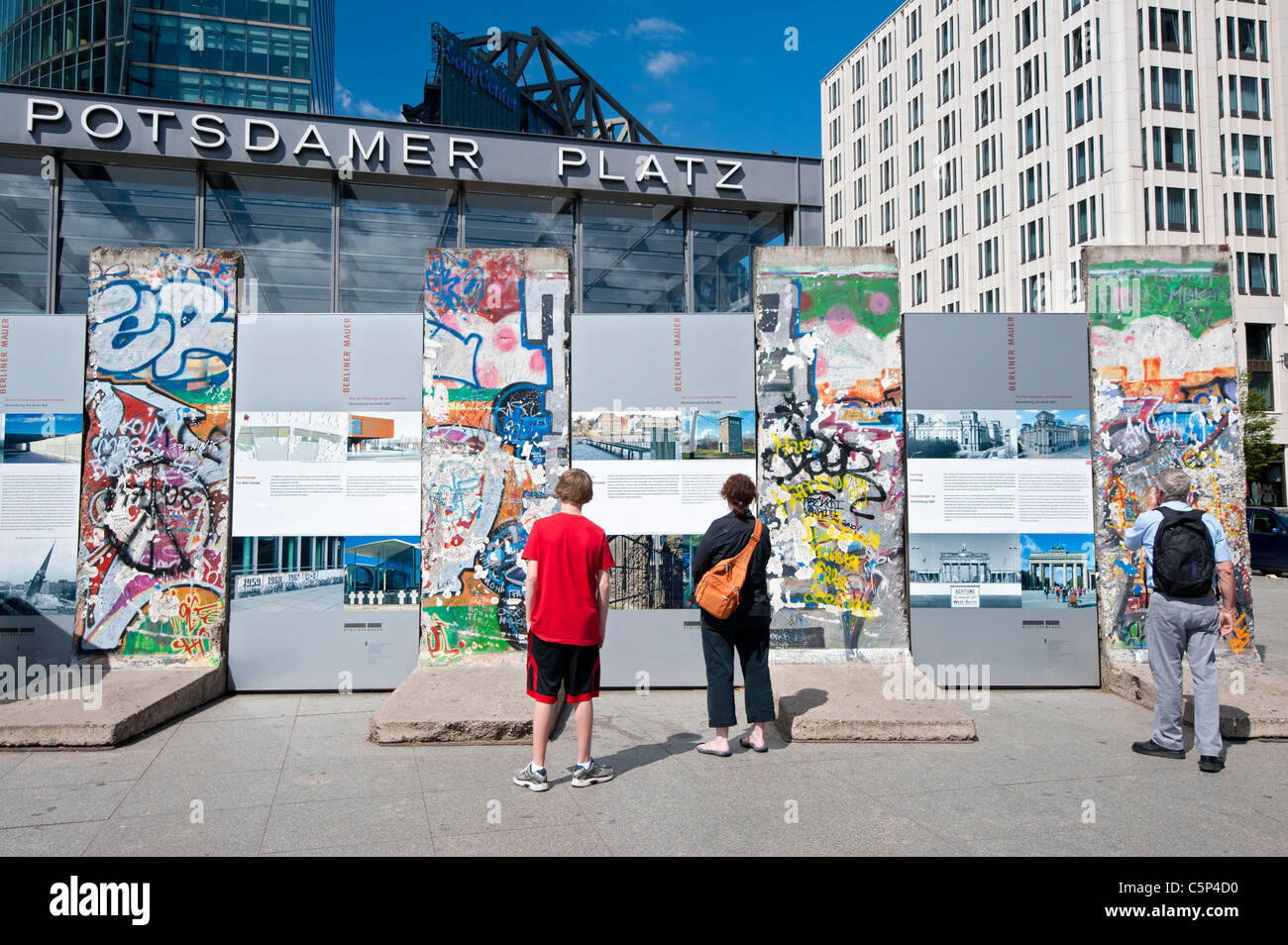 I turisti alla ricerca di sezioni originali del muro di Berlino a Potsdamer Platz a Berlino Germania Foto Stock