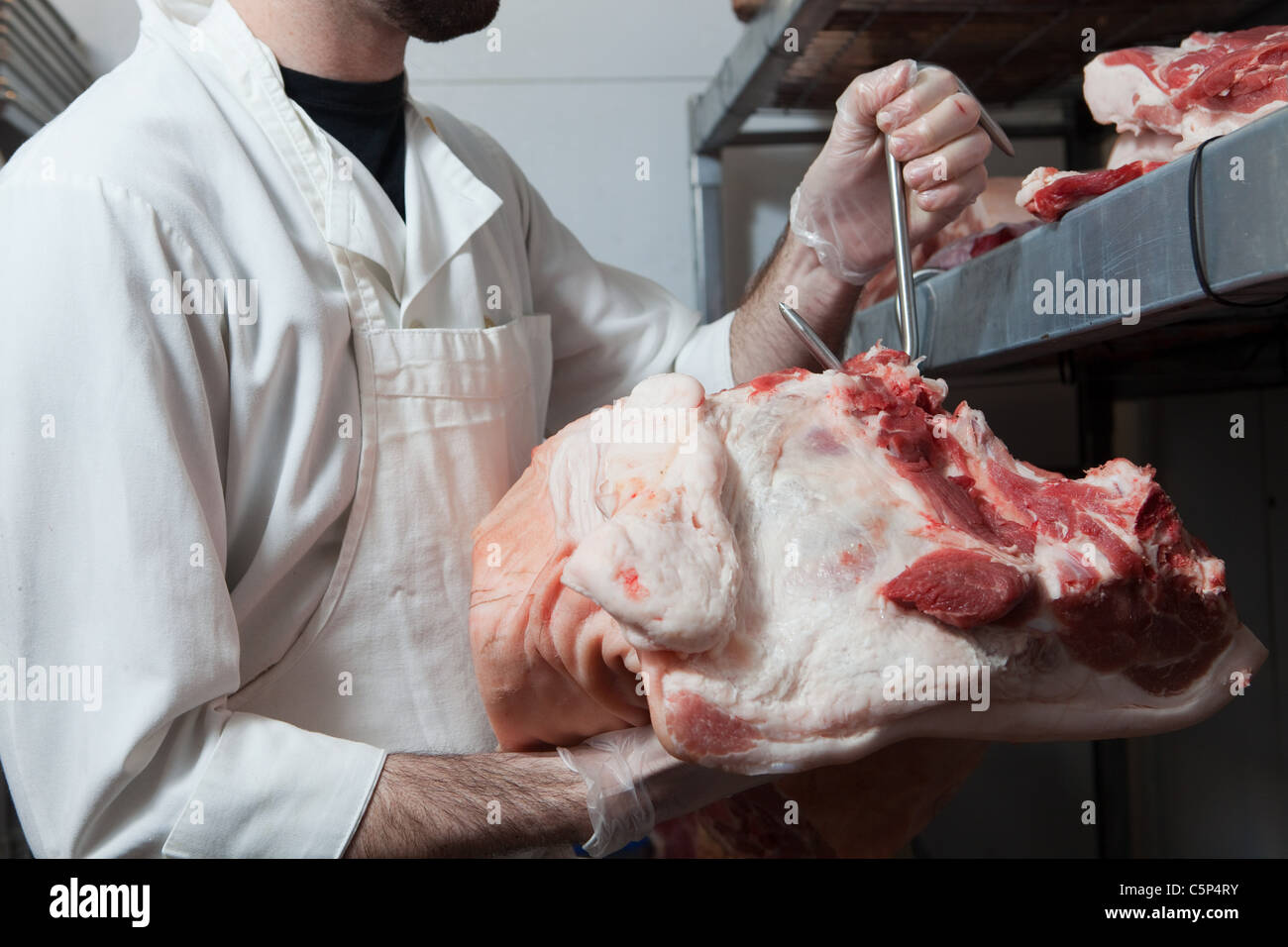 Butcher appendere la testa di vacca Foto Stock