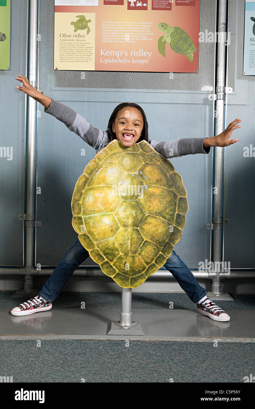Ragazza in piedi dietro kemps ridley sea turtle shell Foto Stock