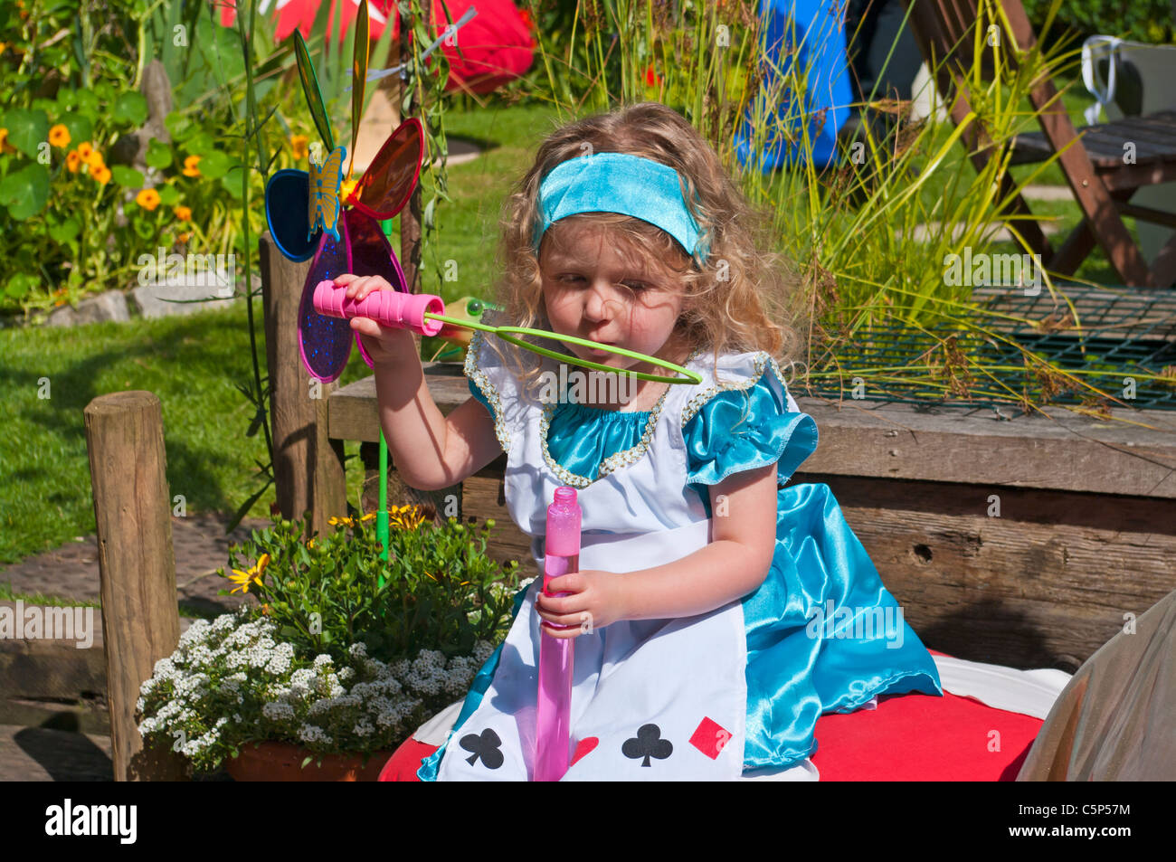 Bambina vestito di Alice nel Paese delle Meraviglie Costume soffiare bolle  Foto stock - Alamy