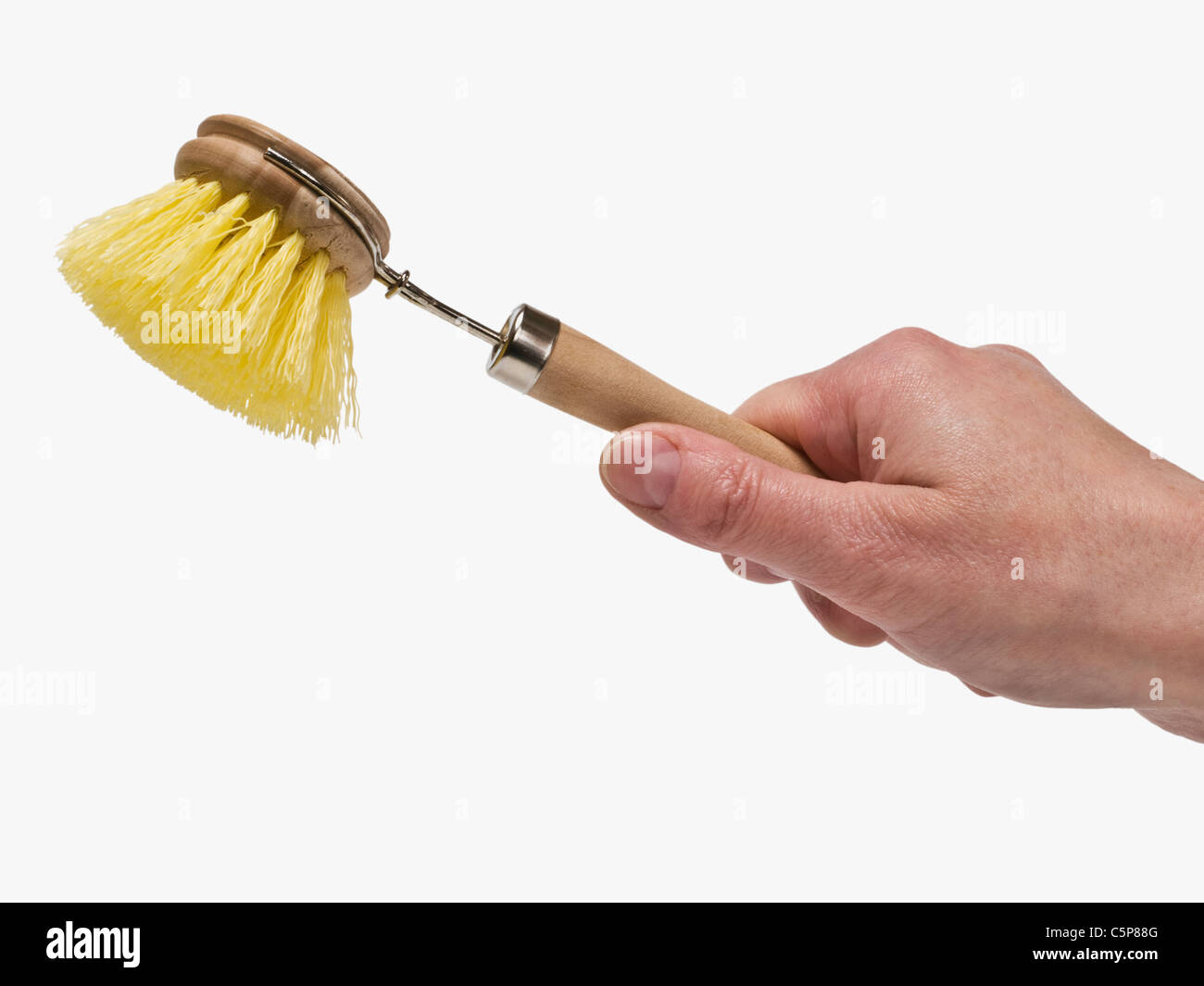 Eine Haushaltsspülbürste wird in der gehalten mano | una spazzola per lavare i piatti è di tenere in mano Foto Stock