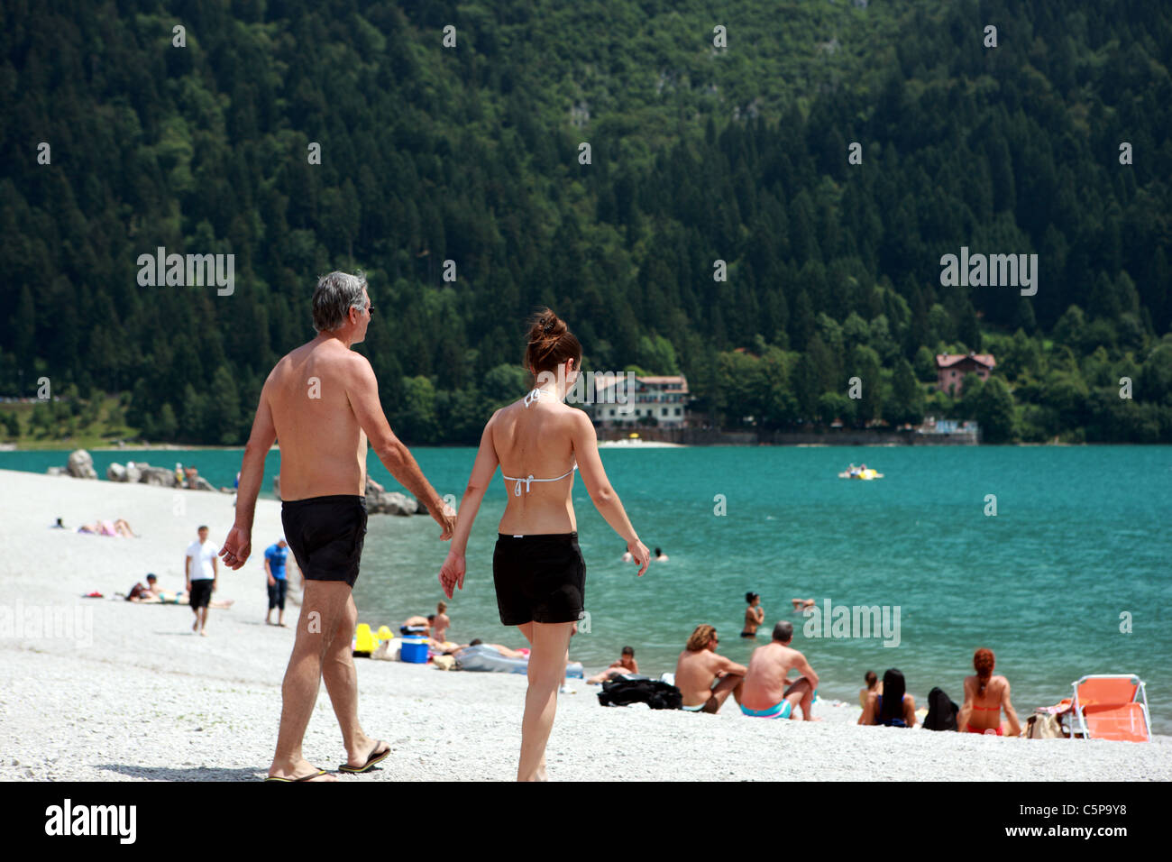 La gente a prendere il sole sulla riva del lago di Molveno in Trentino Foto Stock