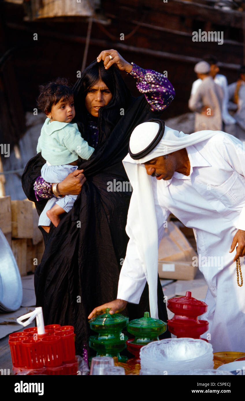 Dubai EMIRATI ARABI famiglia al Souk azienda madre bambino mentre Padre contiene grani di preghiera e guardando Pots Foto Stock
