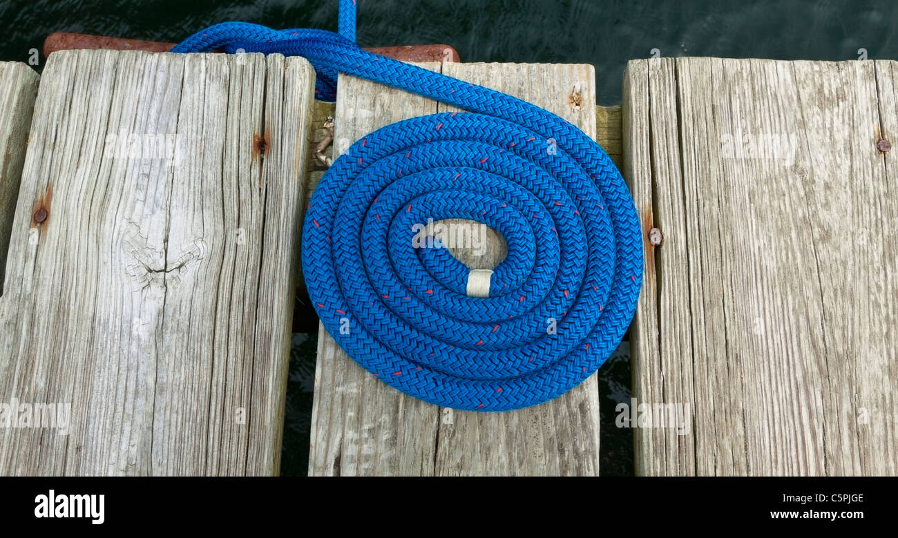 Blu a spirale cima nautica rigging su un pontile in legno. Foto Stock