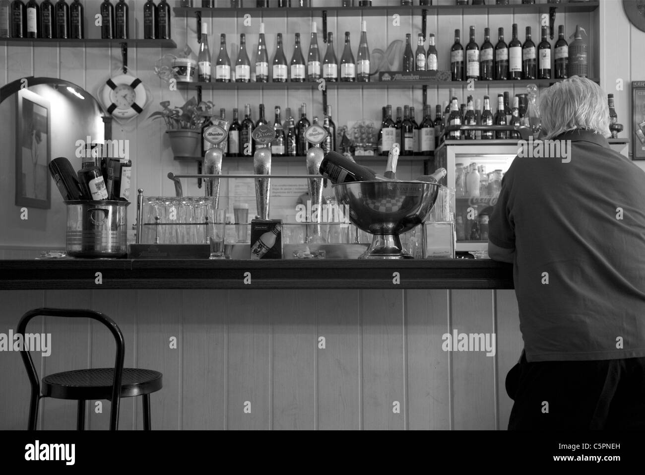 Fotografia in bianco e nero di tipici bar spagnolo con connettore maschio di tipo cliente seduto su uno sgabello da bar Foto Stock
