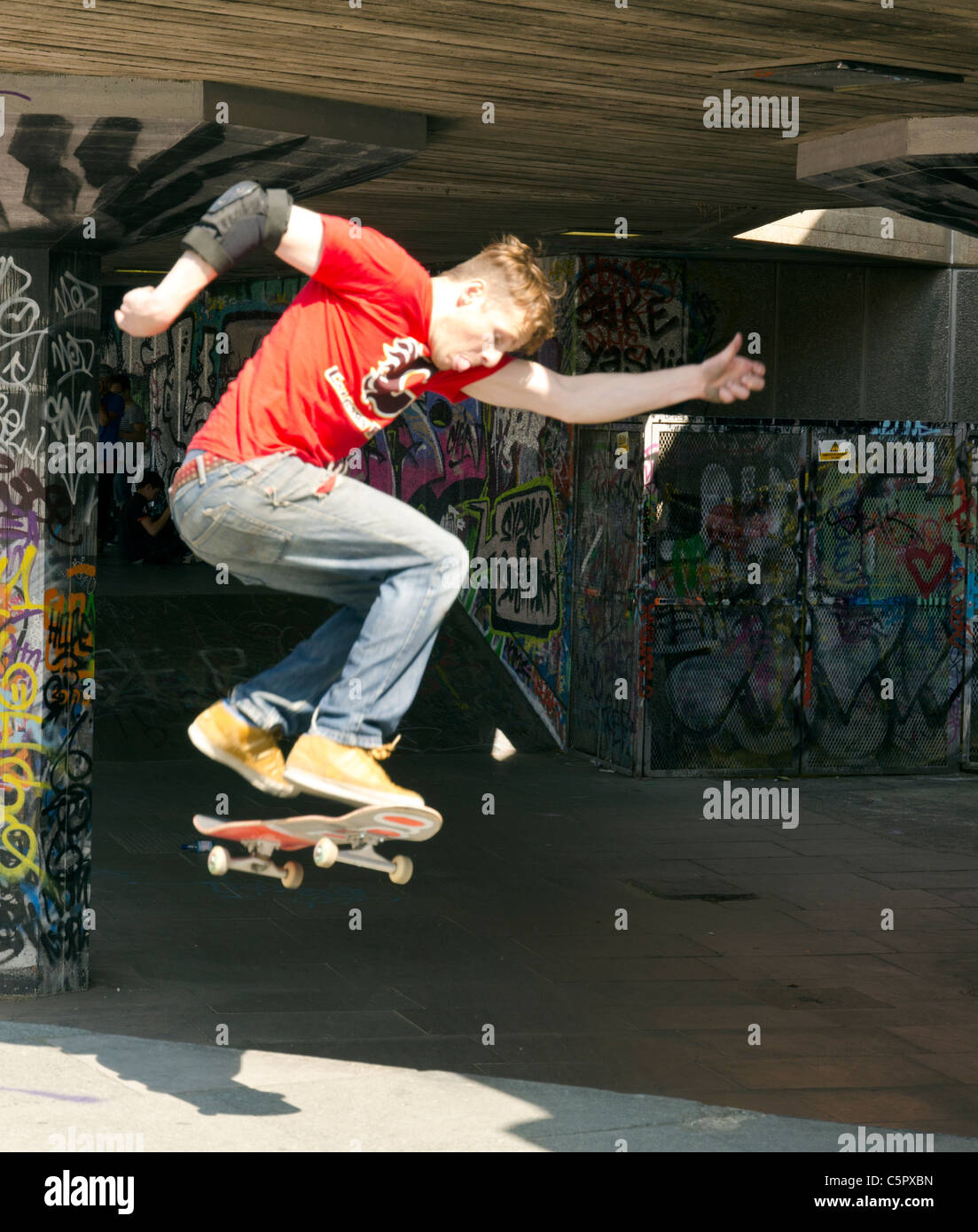Guidatore di skateboard in azione nella zona sottostante al Queen Elizabeth Hall a South Bank di Londra, Inghilterra, Gran Bretagna, Regno Unito Foto Stock