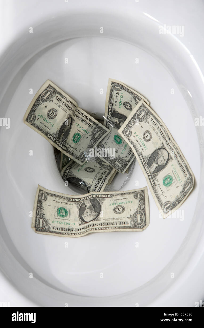 Il lavaggio US Dollar Bills giù il wc Foto Stock