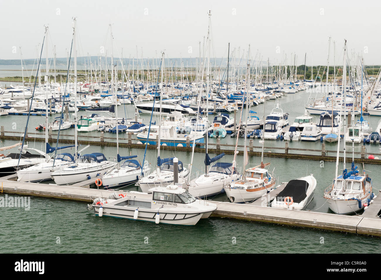 Un certo numero di costosi yacht line-up ormeggiata in un porto vicino a Solent estuario a Lymington, Hampshire. Foto Stock