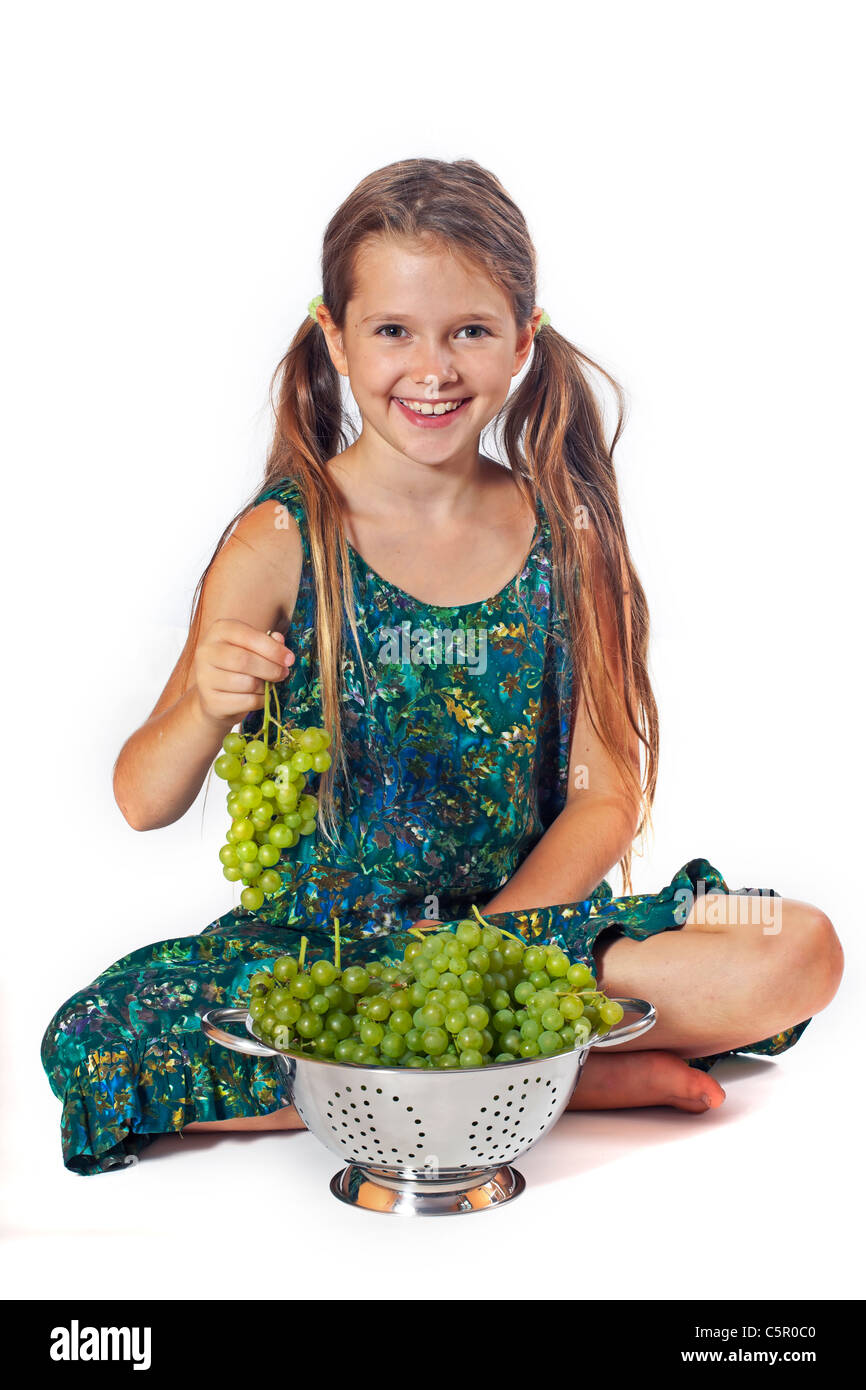 8 anno vecchia ragazza mangiare appena raccolto di uve dal giardino Foto Stock