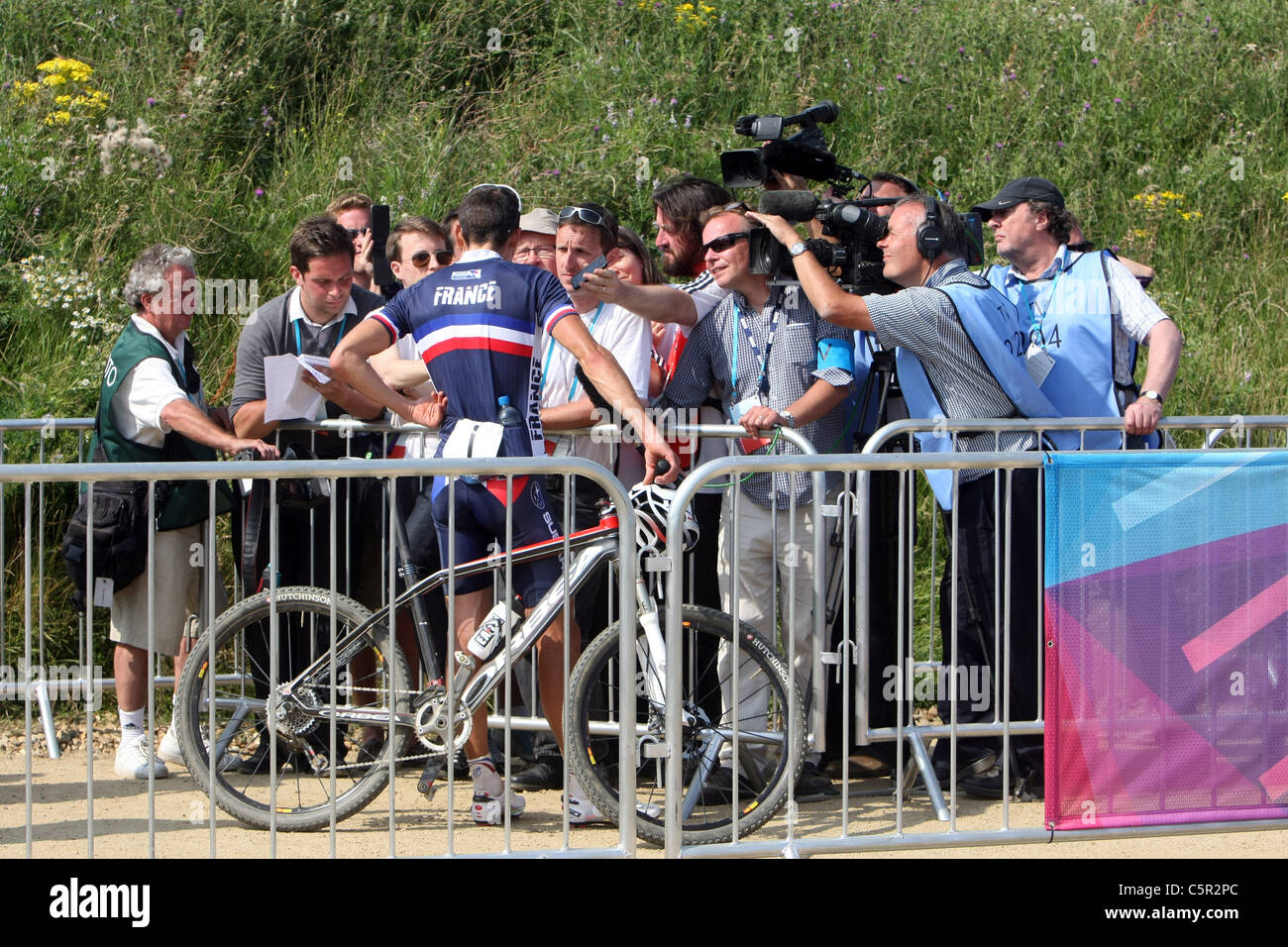 Mens gara su 7 giri. Il vincitore Julien Absalon fra essere intervistato dai media francesi. Mens gara. Hadleigh Farm Mountain Bike internazionale. Londra si prepara per le Olimpiadi 2012. Hadleigh Farm. Essex. 31/07/2011. Foto Stock