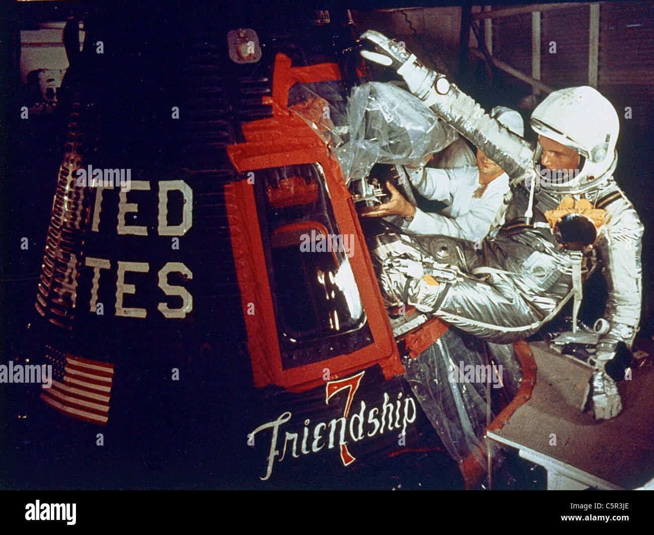 Astronauta John Glenn entra nella sua amicizia 7 capsula con assistenza di tecnici Foto Stock